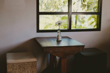 Evdeki oturma odasında deri yastıklı tahta sandalye taburesi.