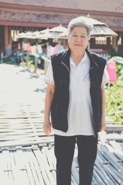 Asyalı yaşlı yaşlı kadın yaşlı kadın bahçede dinleniyor. son sınıf eğlence yaşam tarzı