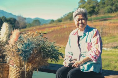 Asyalı yaşlı kadın yaşlı kadın teras balkonunda dinleniyor. son sınıf eğlence yaşam tarzı