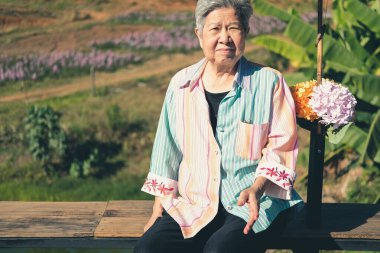 Asyalı yaşlı kadın yaşlı kadın teras balkonunda dinleniyor. son sınıf eğlence yaşam tarzı