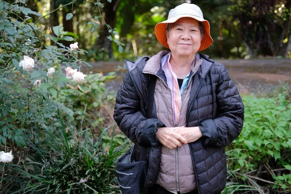 アジアのお年寄りのおばあさんが花の庭でリラックス シニアレジャーライフスタイル — ストック写真