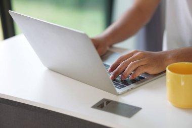 Asyalı genç öğrenci genç girişimci bilgisayarla çalışıyor evde internetten öğrenim görüyor. Webinar toplantısını öğreniyorum. Covid salgınında sosyal uzaklık