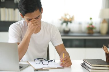 Asyalı genç öğrenci genç girişimci. Çok çalışıyor. Sıkıntıdan patlıyorum. iş eğitimi evde