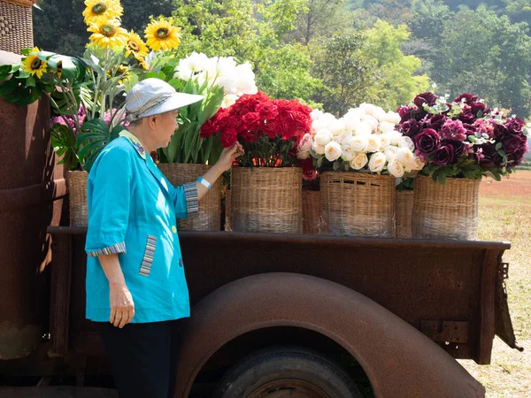 亚洲的老年老年妇女 在花园里抱着花 老年人休闲生活方式 — 图库照片