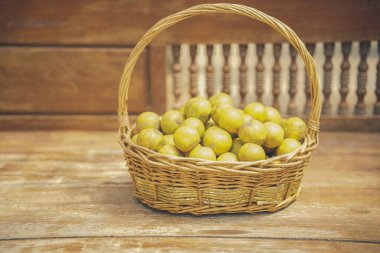 Tahta sandalyede turuncu mandalina meyvesi sepeti.