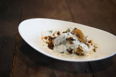 Ekşi krema soslu fırında patates ve bitki.