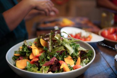 Kadın mutfakta sebze salatası hazırlıyor.