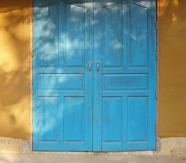 Μπλε Ξύλινη Πόρτα Και Κίτρινο Τοίχο Του Σπιτιού Της Γης Εικόνα Αρχείου
