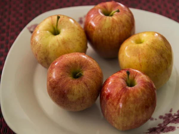 Red apple on white dish — Stock Photo, Image