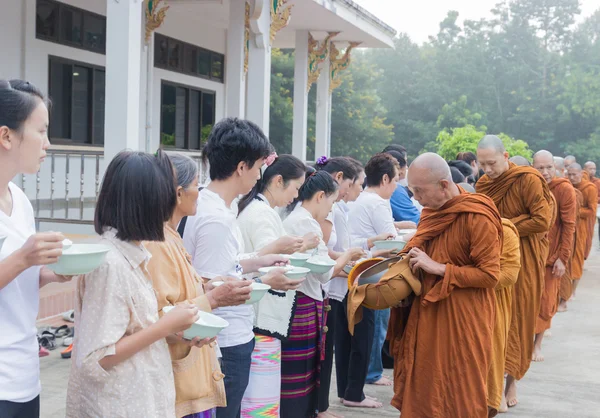 人们把供品放在一个和尚化缘的碗，使 — 图库照片