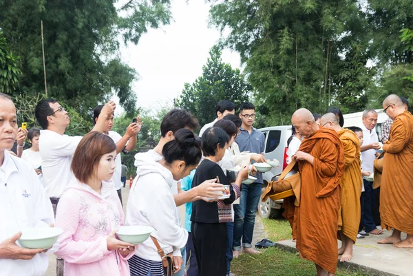 人们把供品放在一个和尚化缘的碗，使 — 图库照片