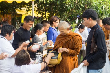 Kişi bir Budist keşiş 's sadaka kase için vir gıda teklifleri koymak