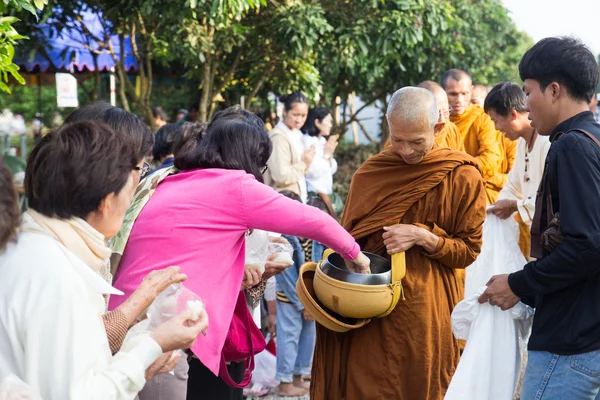 Lidé dát nabídky potravin v buddhistický mnich almužny mísa pro vir — Stock fotografie