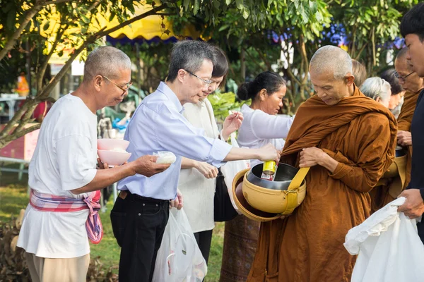 Lidé dát nabídky potravin v buddhistický mnich almužny mísa pro vir — Stock fotografie