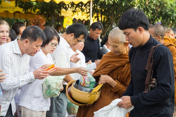 Lidé dát nabídky potravin v buddhistický mnich almužny mísa pro vir — Stock fotografie