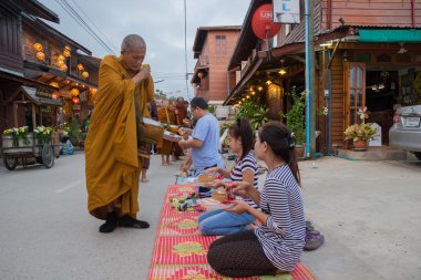 Kişi bir Budist keşiş 's sadaka kase goo için gıda teklifleri koymak