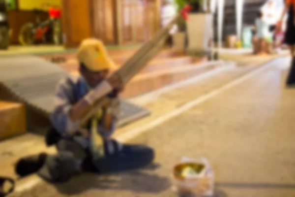 L'immagine sfocata di musicista di strada asiatica suonare canna bocca org — Foto Stock