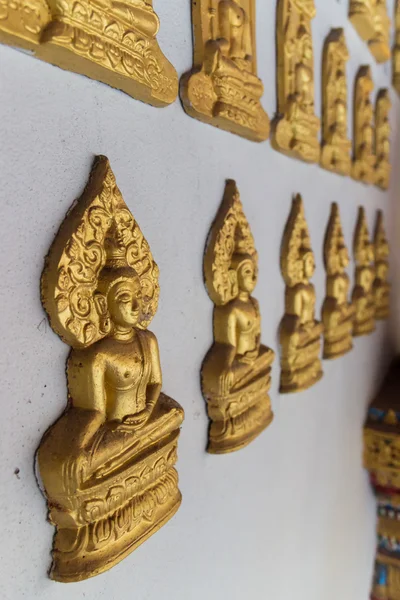 Golden buddha skulptur på templet väggen — Stockfoto