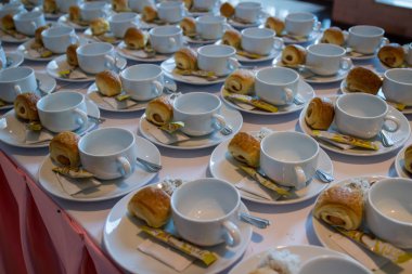 birçok bardak fincan tabağı üzerinde kaşık, sütsüz krema ve şeker ile boş