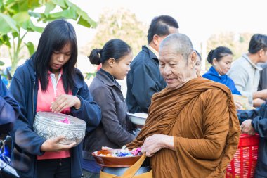 İnsanlar yemek Budist keşiş sadaka kase koymak.