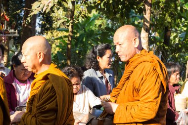 İnsanlar yemek Budist keşiş sadaka kase koymak.