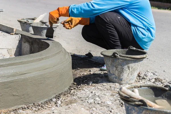 Il lavoratore applica cemento sulla superficie del bordo del sentiero — Foto Stock