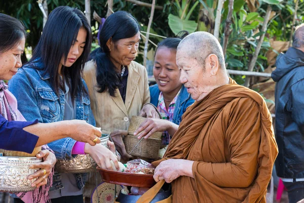 Lidé dát jídlo na buddhistický mnich almužny mísa — Stock fotografie