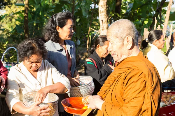 Lidé dát jídlo na buddhistický mnich almužny mísa — Stock fotografie