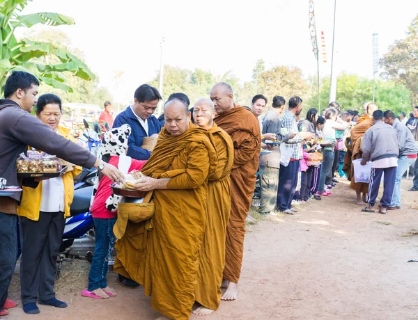 Människor sätter mat på buddhistisk munk alms skål — Stockfoto
