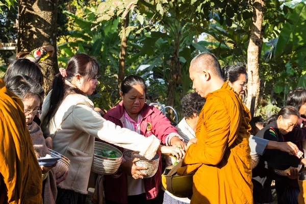 Lidé dát jídlo na buddhistický mnich almužny mísa — Stock fotografie