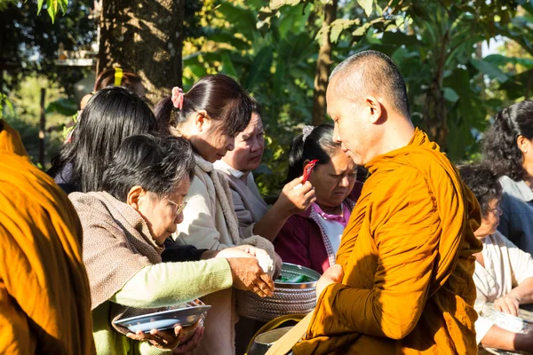 Lidé dát jídlo na buddhistický mnich almužny mísa — Stock fotografie