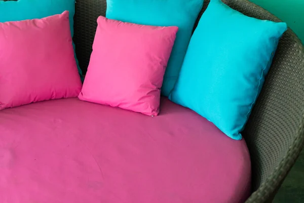 粉色和蓝色棕色藤沙发上的枕头 — 图库照片