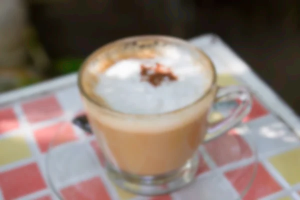 Café desenfocado desenfocado de capuchino caliente con cobertura de canela para — Foto de Stock