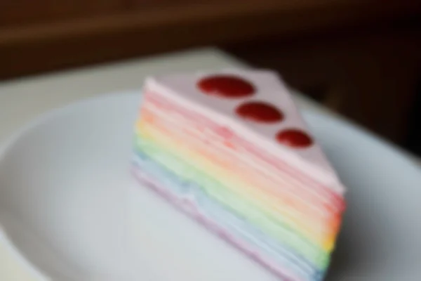 Verschwommen defokussierten Regenbogen-Crepe-Kuchen mit Erdbeersoße Toppin — Stockfoto