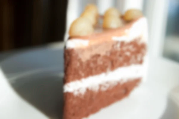 Bolo de chocolate desfocado embaçado com macadâmia em cima para backgr — Fotografia de Stock