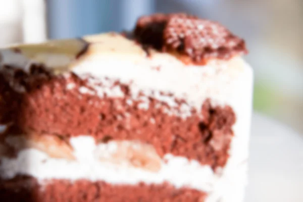 Verschwommene defokussierte Schokoladenkuchen mit Sahne und Banane für Backgr — Stockfoto