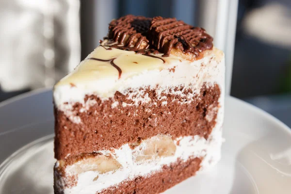 Chocolate cake with cream and banana — Stock Photo, Image