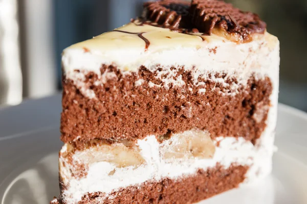 Chocolate cake with cream and banana — Stock Photo, Image