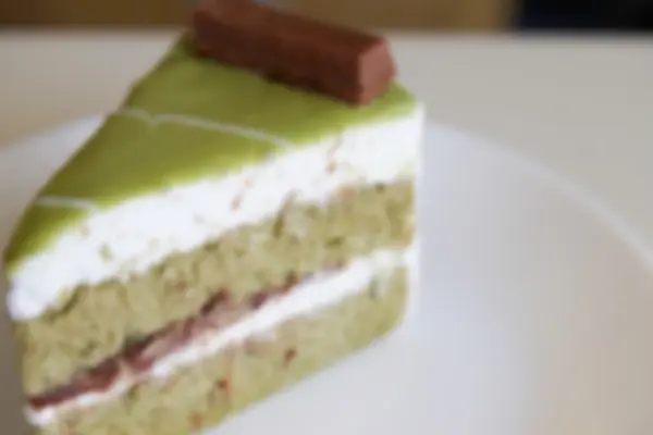Rozmazaný rozostřeného obrazu zelený čaj dort s červeným fazolové pasty ležela — Stock fotografie