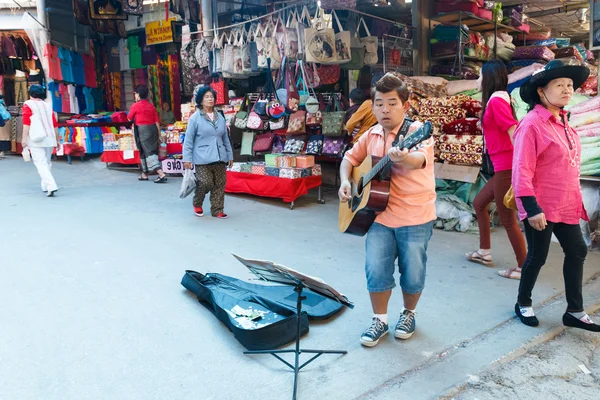 Músico de rua tocando guitarra no mercado local . — Fotografia de Stock