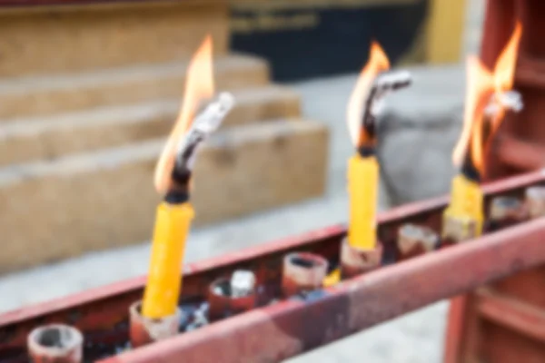 Imagen desenfocada borrosa de llama de vela en el templo para backgrou — Foto de Stock
