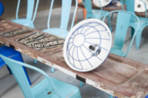 Verschwommenes defokussiertes Bild eines blauen Metallstuhls mit alter Holztür — Stockfoto