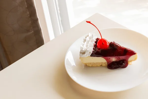 Blueberry cheese cake with cherry on top — Stock Photo, Image