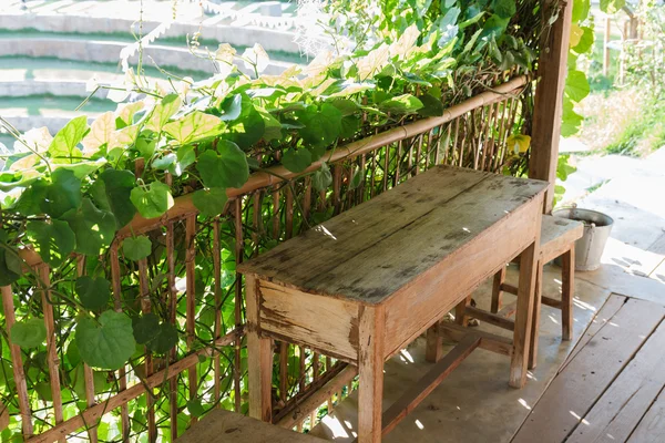 Drewniany stół i krzesła obok ogrodu — Zdjęcie stockowe