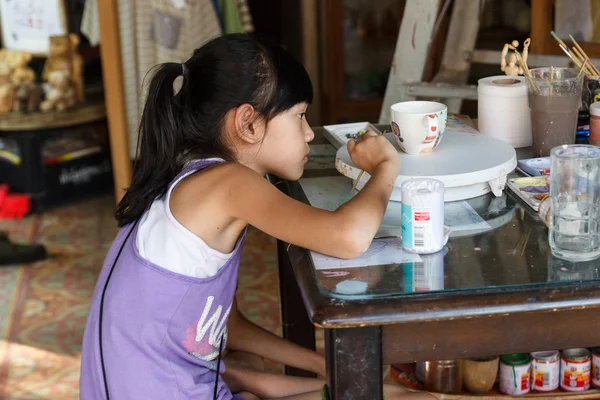 La chica está pintando el tazón — Foto de Stock