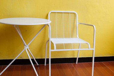 Beyaz sandalye ve masa sarı duvar ile