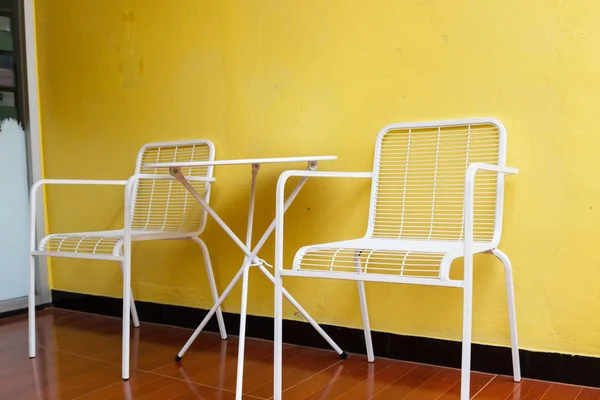白色的椅子和桌子跟黄墙 — 图库照片