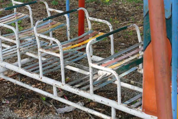 Viejo asiento de metal en el patio de niños —  Fotos de Stock