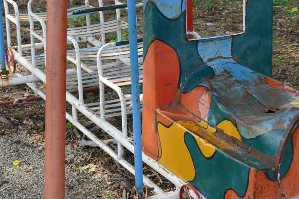 Viejo asiento de metal en el patio de niños —  Fotos de Stock