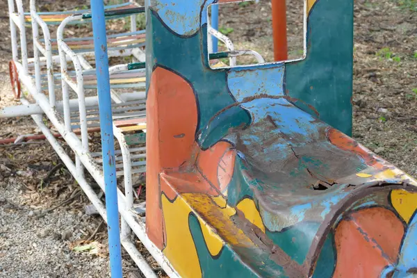 Viejo asiento de metal en el patio de niños —  Fotos de Stock